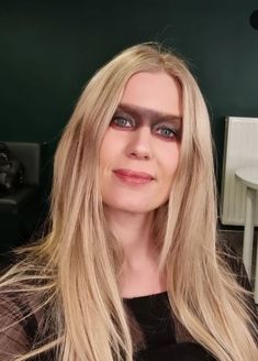 a woman with long blonde hair and black makeup