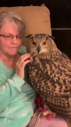 an older woman is sitting on a couch with an owl