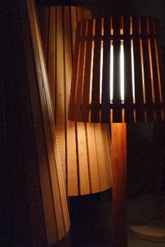 a lamp that is sitting next to a wooden flooring planked wall in the dark