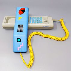 an old style telephone has been painted blue and yellow