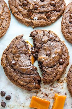 chocolate cookies and cheese are on a baking sheet, with one bite missing from the cookie