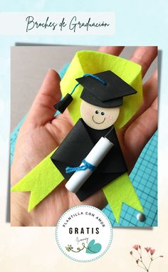 a hand holding a piece of paper with a graduate figure on it