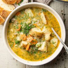 a white bowl filled with soup next to bread