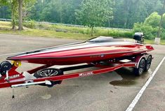 a red speed boat parked in a parking lot