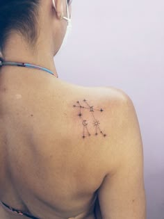 the back of a woman's shoulder with stars on her left side and an arrow in the middle