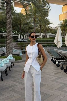 Embrace timeless sophistication with this old money-inspired outfit. Featuring a classy white linen pants paired with a white top and a brown basket, this look exudes elegance and refinement. Perfect for any stylish occasion. #OldMoneyStyle #ElegantFashion #WhiteShirtDress #BalletFlats #TimelessElegance #ClassyOutfit #FashionInspo #OOTD #ChicStyle #SophisticatedLook Vest And Pants Outfits For Women, Style Linen Pants Outfit, Classy And Elegant Outfits For Women, Summer Work Fits, Summer Outfit 2024, How To Style A Vest Women, Linen Outfits For Women Classy, Classy Outfits Summer, Linen Clothes For Women Classy