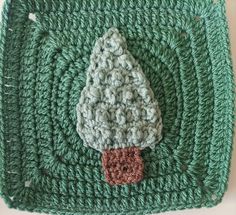 a crocheted square with a small tree on it