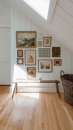 there are many pictures on the wall in this room with wood flooring and white walls