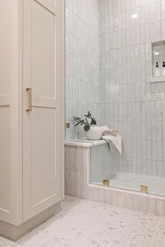 a bathroom with white tile walls and floor