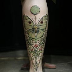 a woman's leg with a butterfly tattoo on it and an apple in the background