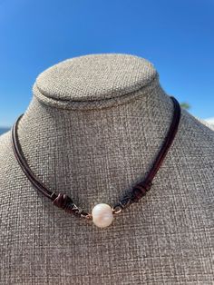 Classic yet Modern and Trendy Necklace. This could be worn by anyone who loves pearls and wants a classic look for a dressier attire or just to wear with a simple tee and jeans. I selected a dark cherry brown leather that is 2mm in size and doubled the strands. The strands of leather are triple barrel knotted as an accent to the beautiful creamy freshwater cultured pearl in the center. The pearl is 12mm in size. It is secured to the necklace with copper accents.  There is a magnetic clasp for easy on and off. I know you will love this with so many styles of clothing to business casual, coastal, boho, western wear and just a simple tee shirt and jeans.  This would also look amazing in the collar of your favorite dress shirt or denim jacket. This is a One of A Kind necklace. Elegant Brown Single Strand Pearl Necklace, Elegant Single Strand Brown Pearl Necklace, Dressy Attire, Cherry Brown, Casual Coastal, Coastal Boho, Trendy Necklace, Copper Accents, Simple Tees