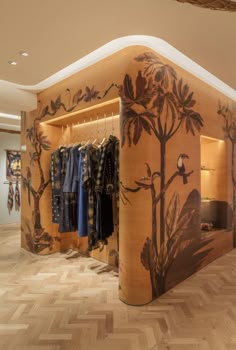 the inside of a clothing store with wood flooring and wall murals on the walls