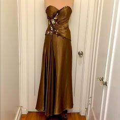 a brown dress on display in front of a white door with wood flooring and wooden floors