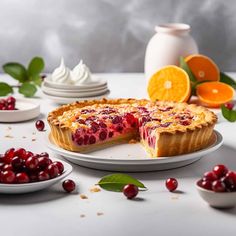 a pie with cranberries and oranges on the side