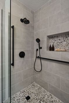 A transitional shower design with river rock floor and large format grey tile on the walls. Matte black fixtures. Restroom Remodel, Tub To Shower Remodel, Full Bathroom Remodel, Master Shower, Bathroom Redesign, Bathroom Remodel Designs, Bathroom Remodel Shower, Shower Remodel, Bathroom Remodel Master