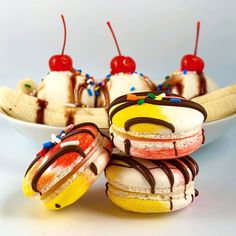 three ice cream sandwiches are sitting on a plate with bananas and cherries in the background