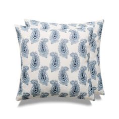 two pillows with blue and white designs on them, one in the shape of a peacock