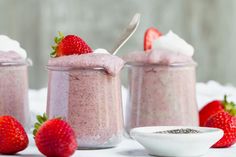 three small jars filled with different types of food and one has a spoon in it