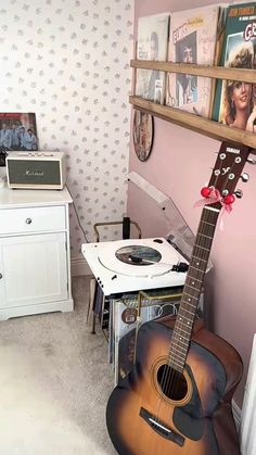 a room with a guitar, record player and other items