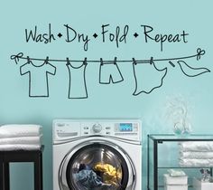 wash dry fold repeat wall decal with clothes hanging on the line and laundry in front of it