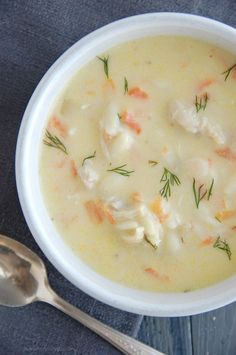 a bowl of chicken and dumpling soup with a spoon next to it on a table