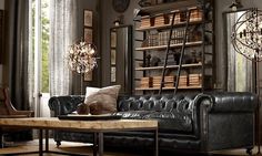 a living room with black leather furniture and bookshelves