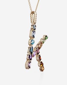 The yellow gold pendant is illuminated by a veritable rainbow of natural gemstones such as topaz, garnet, amethyst, citrine, peridot and tourmaline. the shades of their colours, dominated by blue, green, purple, red, pink and yellow, evoke the warm atmospheres of Sicily. The multiple shapes of the crystals are also emphasized by the bezels, which alternate twisted thread processing and smooth surfaces. The chain, also in yellow gold and wearable in different lengths, includes a teardrop pearl at the end and a small pendant DG logo, which for the very first time embellishes a Dolce & Gabbana Fine Jewellery creation. Technical specifications. Gold yellow 18 Kt. Length. 15.8 + 2 + 2 inches, 40 + 5 + 5 cm adjustable. Gemstones., n.1 oval purple amethyst, n.1 oval pink tourmaline, n.1 rectangul K Pendant, Rainbow Alphabet, Initial K, Pearl Amethyst, Logo Jewelry, Gold Topaz, Gold Necklace Women, Gold Initial, Green Quartz