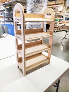 a wooden shelf with shelves on top of it in a warehouse or workshop, ready to be assembled