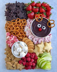 a platter filled with fruit, pretzels, cookies and other food items