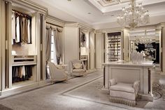 an elegant dressing room with chandelier, chair, and closet full of clothes