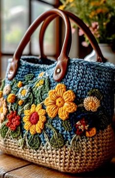 a purse with flowers on it sitting on top of a wooden table