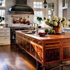 a large kitchen with an island in the middle and potted plants on the counter