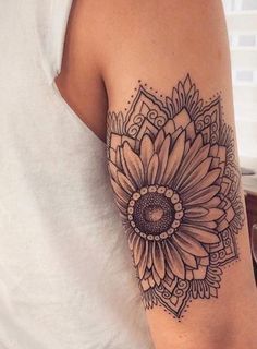 a woman's arm with a sunflower tattoo on it