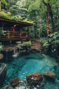 a small pool in the middle of a forest with steps leading up to it and a deck above