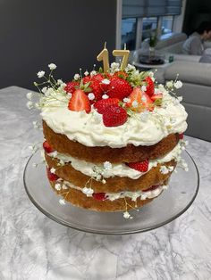 a birthday cake with strawberries and flowers on top