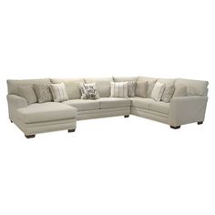 a large sectional couch with pillows on the back and side ends, sitting in front of a white background