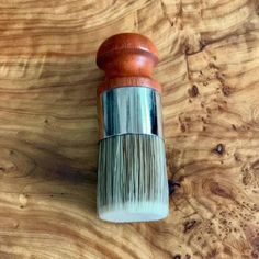 a wooden and metal brush sitting on top of a table