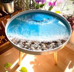 a round table with an ocean scene painted on the top and pebbles in the bottom