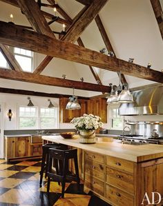 a large kitchen with an island in the middle and lots of lights hanging from the ceiling