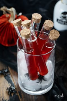 several bottles filled with liquid sitting on top of a wooden table next to halloween decorations