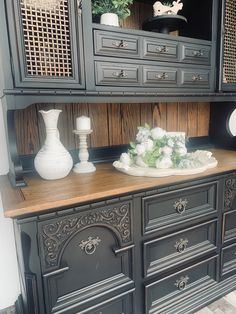 an ornately decorated china cabinet with vases on top