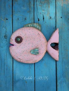 a pink fish that is sitting on some blue wood