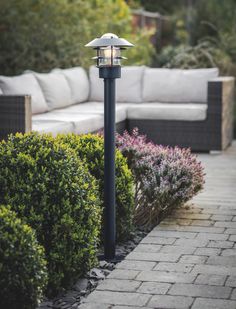 a black lamp post sitting in the middle of a garden