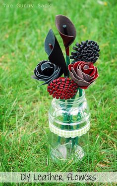 an arrangement of flowers in a mason jar on the grass with text overlay that says diy leather flowers