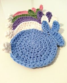 three crocheted hats are sitting next to each other on a white counter top