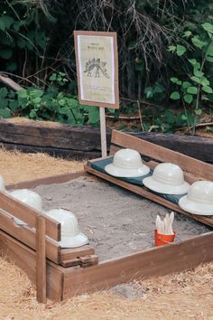 a bed made out of sand with white hats on it