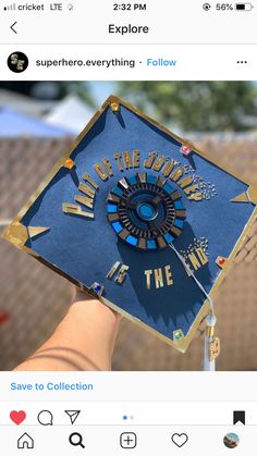 someone holding up a blue graduation cap with gold lettering