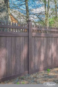 a wooden fence in front of some trees