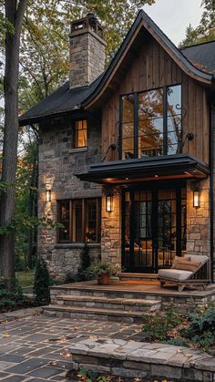 a stone and wood house with steps leading up to the front door