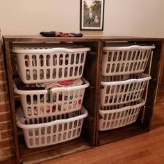 baskets are stacked on top of each other in front of a brick wall and wooden floor